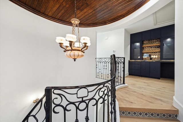 721 Harborside Way, League City, TX 77565 - staircase with wooden ceiling, ornamental molding, a chandelier, wood finished floors, and bar area