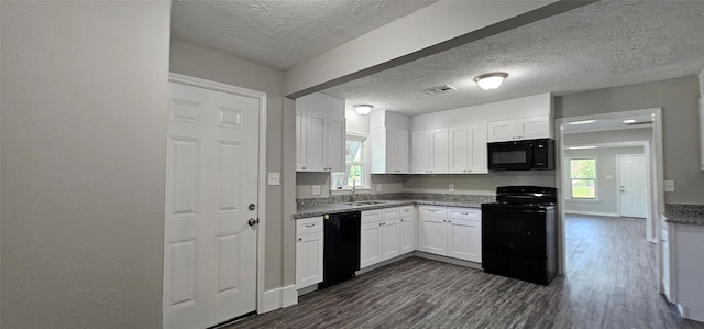 215 San Jacinto St, Highlands, TX 77562 - kitchen with black appliances, a textured ceiling, a sink, white cabinetry, and dark wood-type flooring