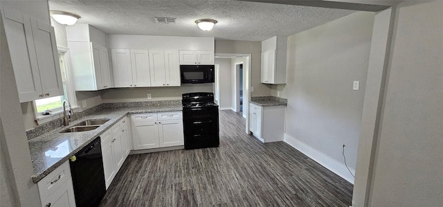 215 San Jacinto St, Highlands, TX 77562 - kitchen with black appliances, a sink, baseboards, dark wood-style floors, and stone counters