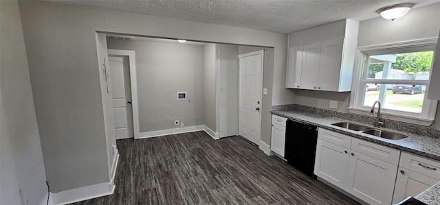 215 San Jacinto St, Highlands, TX 77562 - kitchen with black dishwasher, a sink, dark wood-type flooring, white cabinets, and baseboards