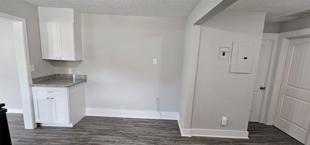 215 San Jacinto St, Highlands, TX 77562 - kitchen with electric panel, white cabinets, dark wood finished floors, baseboards, and light stone counters