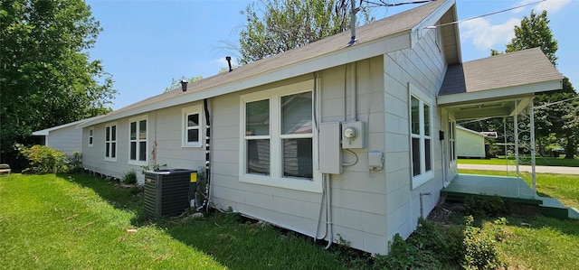 215 San Jacinto St, Highlands, TX 77562 - view of side of home featuring central AC, a lawn, and a shingled roof