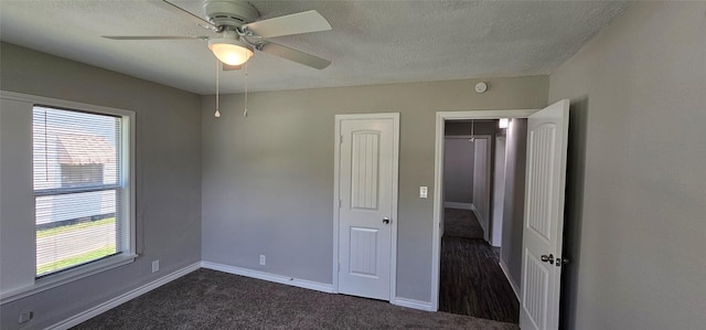 215 San Jacinto St, Highlands, TX 77562 - unfurnished bedroom with multiple windows, dark colored carpet, baseboards, a textured ceiling, and ceiling fan