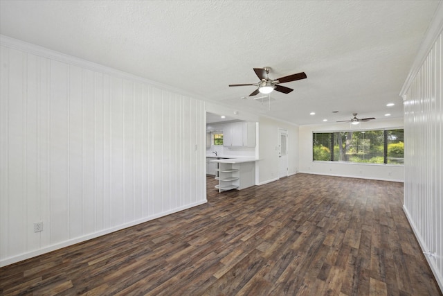 1309 Centennial Dr, Houston, TX 77055 - unfurnished living room with dark wood-style floors, baseboards, ceiling fan, crown molding, and a textured ceiling