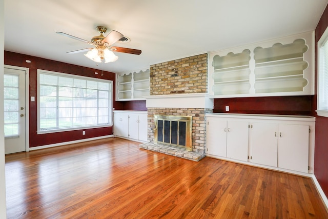 10134 Brinwood Dr, Houston, TX 77043 - unfurnished living room with a ceiling fan, light wood-style flooring, and a fireplace