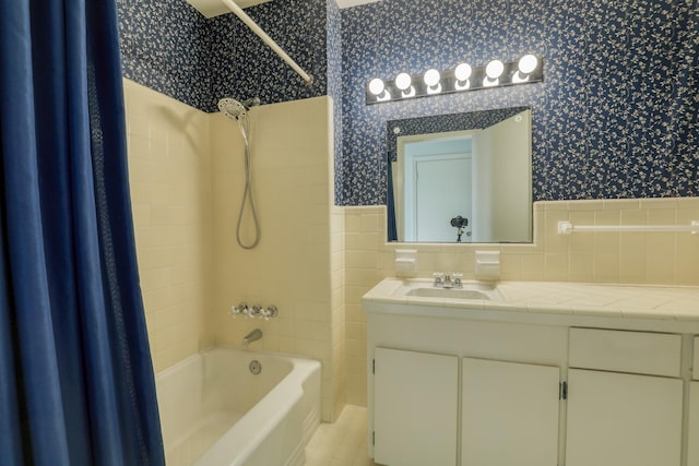 10134 Brinwood Dr, Houston, TX 77043 - bathroom featuring wallpapered walls, shower / tub combo with curtain, wainscoting, vanity, and tile walls