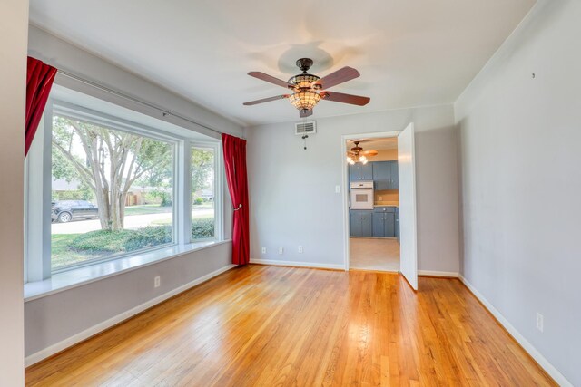 10134 Brinwood Dr, Houston, TX 77043 - empty room featuring light wood-type flooring, a ceiling fan, and baseboards