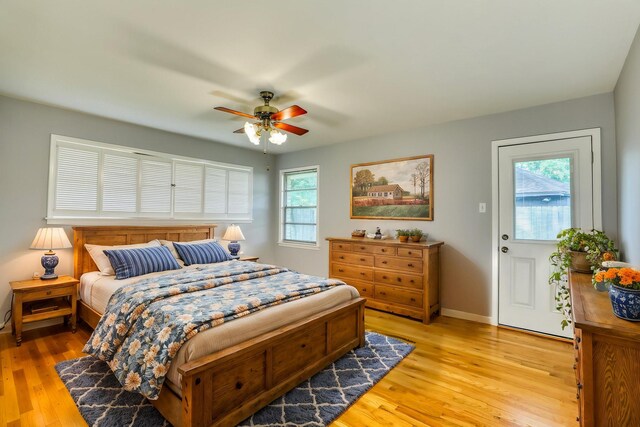 10134 Brinwood Dr, Houston, TX 77043 - bedroom featuring multiple windows, light wood-style floors, baseboards, and ceiling fan