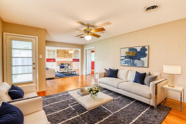 10134 Brinwood Dr, Houston, TX 77043 - living room featuring wood finished floors, ceiling fan, and a brick fireplace