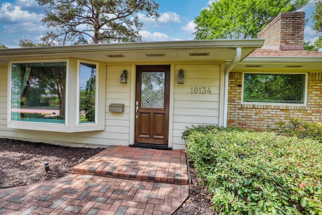 10134 Brinwood Dr, Houston, TX 77043 - doorway to property featuring a chimney and brick siding