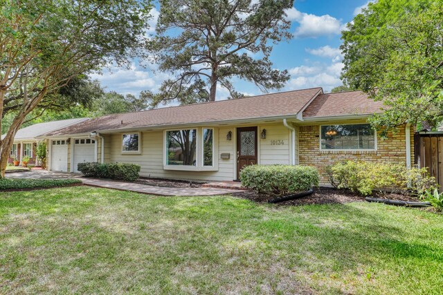 10134 Brinwood Dr, Houston, TX 77043 - ranch-style house with an attached garage, a front yard, a shingled roof, and driveway