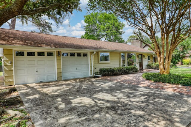 10134 Brinwood Dr, Houston, TX 77043 - single story home featuring concrete driveway, an attached garage, a chimney, and a shingled roof