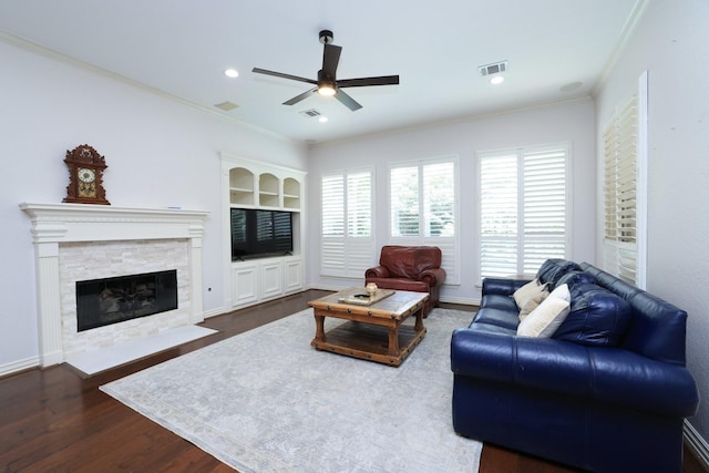 6 Lovenote Ct, The Woodlands, TX 77382 - living area featuring ceiling fan, dark wood-type flooring, crown molding, a stone fireplace, and built in shelves