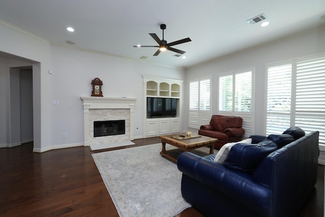 6 Lovenote Ct, The Woodlands, TX 77382 - living area with ceiling fan, crown molding, dark wood-style floors, a stone fireplace, and baseboards