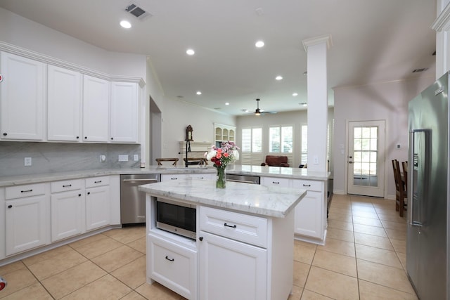 6 Lovenote Ct, The Woodlands, TX 77382 - kitchen featuring stainless steel appliances, a peninsula, light tile patterned flooring, a kitchen island, and recessed lighting