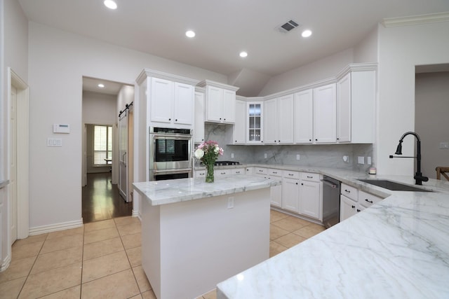 6 Lovenote Ct, The Woodlands, TX 77382 - kitchen with a sink, appliances with stainless steel finishes, light stone counters, tasteful backsplash, and white cabinets