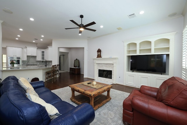 6 Lovenote Ct, The Woodlands, TX 77382 - living room featuring ceiling fan, dark wood-style floors, recessed lighting, crown molding, and a glass covered fireplace