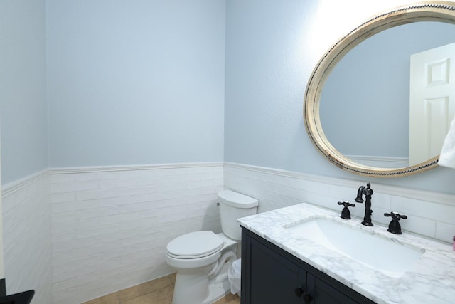 6 Lovenote Ct, The Woodlands, TX 77382 - half bathroom featuring tile walls, vanity, a wainscoted wall, toilet, and tile patterned flooring