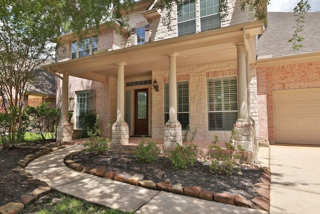 6 Lovenote Ct, The Woodlands, TX 77382 - doorway to property with covered porch, stone siding, a garage, and brick siding