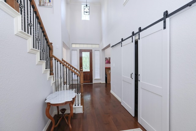 6 Lovenote Ct, The Woodlands, TX 77382 - foyer entrance featuring a barn door, wood finished floors, stairway, and a towering ceiling