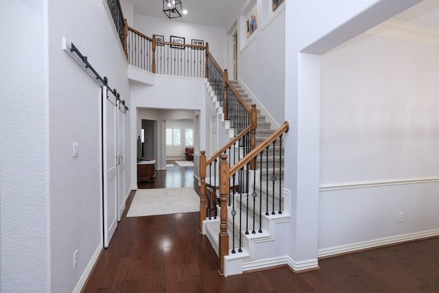 6 Lovenote Ct, The Woodlands, TX 77382 - entrance foyer featuring stairway, dark wood-style floors, and a barn door