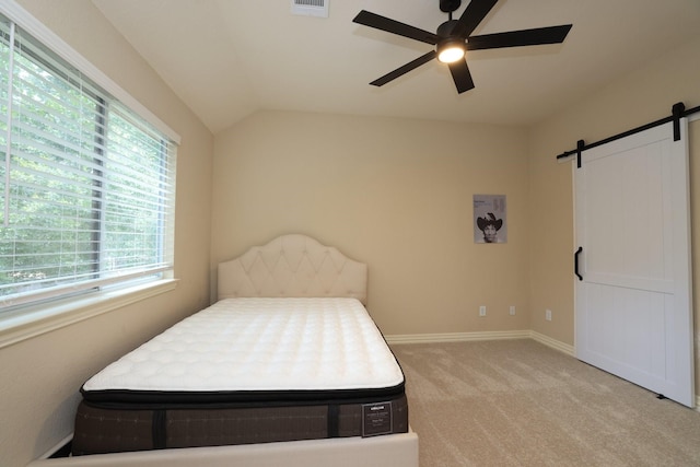 6 Lovenote Ct, The Woodlands, TX 77382 - bedroom featuring a barn door, light carpet, vaulted ceiling, baseboards, and ceiling fan