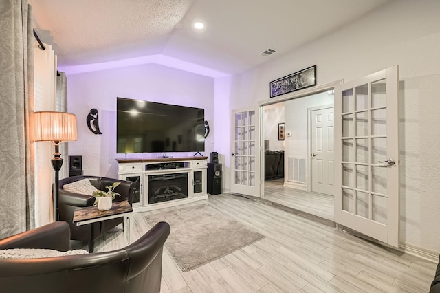 3106 Village Springs Ct, Houston, TX 77339 - living room featuring french doors, wood finished floors, lofted ceiling, baseboards, and a textured ceiling