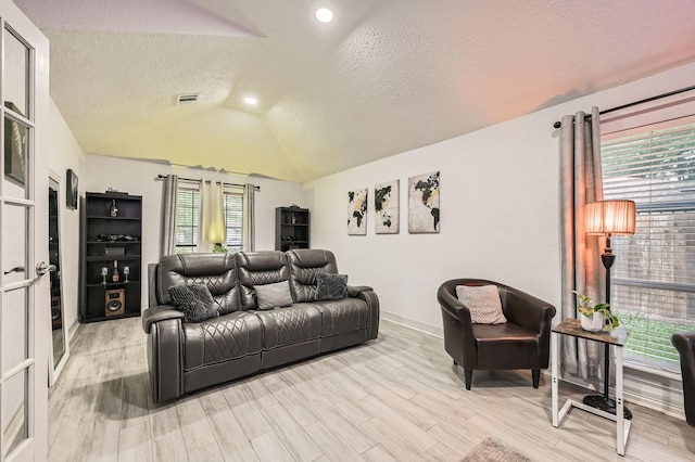 3106 Village Springs Ct, Houston, TX 77339 - living room featuring lofted ceiling, light wood-style floors, a textured ceiling, baseboards, and recessed lighting