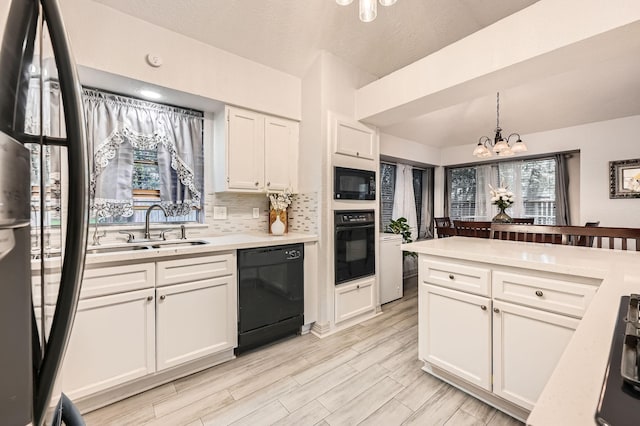 3106 Village Springs Ct, Houston, TX 77339 - kitchen featuring black appliances, a chandelier, light countertops, and white cabinets