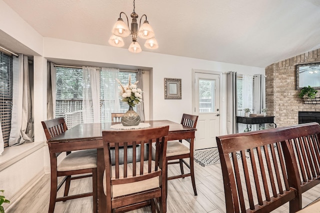 3106 Village Springs Ct, Houston, TX 77339 - dining space with plenty of natural light, a chandelier, light wood-type flooring, lofted ceiling, and a fireplace
