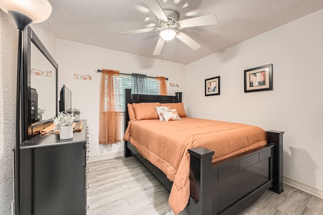3106 Village Springs Ct, Houston, TX 77339 - bedroom with a textured ceiling, light wood-style flooring, baseboards, and a ceiling fan