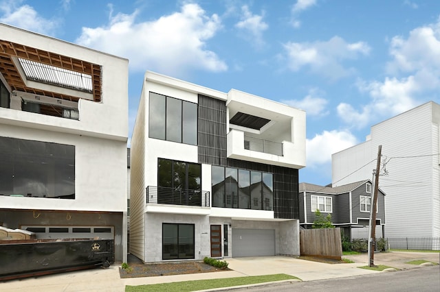 1505 Stuart St, Houston, TX 77004 - view of front facade featuring driveway, a balcony, a garage, and stucco siding