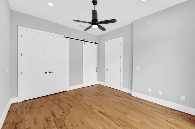 1505 Stuart St, Houston, TX 77004 - unfurnished bedroom featuring baseboards, a barn door, light wood-style floors, and recessed lighting