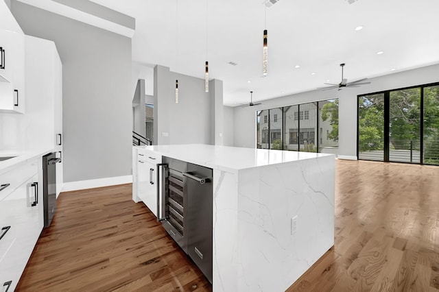1505 Stuart St, Houston, TX 77004 - kitchen featuring modern cabinets, light wood finished floors, a kitchen island, white cabinets, and baseboards