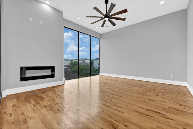 1505 Stuart St, Houston, TX 77004 - spare room featuring ceiling fan, wood finished floors, baseboards, a glass covered fireplace, and recessed lighting