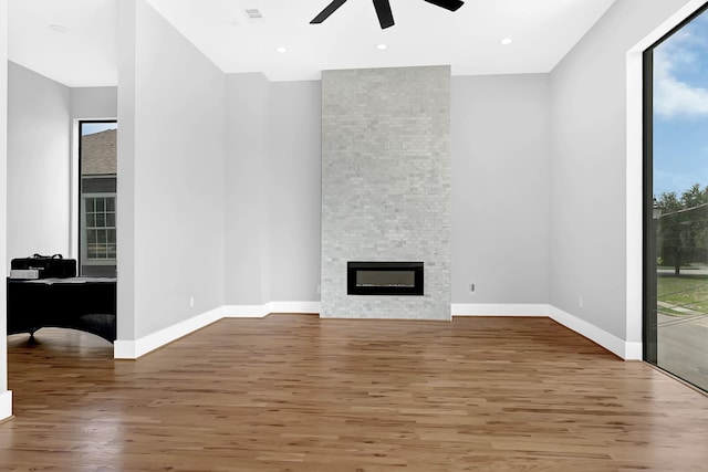 1505 Stuart St, Houston, TX 77004 - unfurnished living room with a ceiling fan, wood finished floors, baseboards, a stone fireplace, and recessed lighting