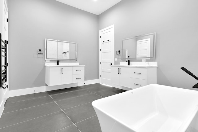 1505 Stuart St, Houston, TX 77004 - full bathroom with two vanities, a soaking tub, tile patterned floors, and baseboards