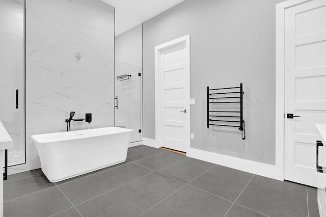 1505 Stuart St, Houston, TX 77004 - full bathroom with a soaking tub, a towel warming rack, tile patterned floors, and a marble finish shower