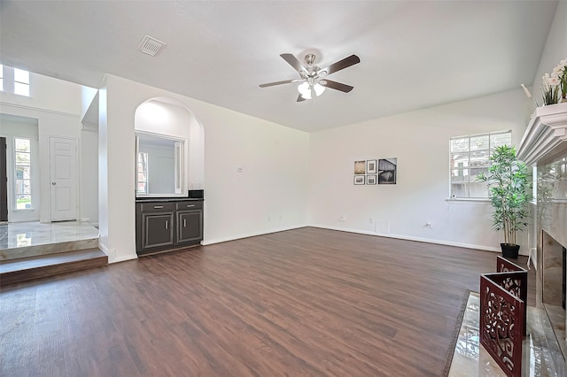 2130 Avenida La Quinta St, Houston, TX 77077 - unfurnished living room featuring ceiling fan, dark wood-type flooring, baseboards, arched walkways, and a premium fireplace