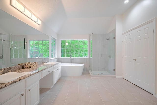 2130 Avenida La Quinta St, Houston, TX 77077 - full bathroom featuring double vanity, a stall shower, a freestanding bath, tile patterned flooring, and vaulted ceiling