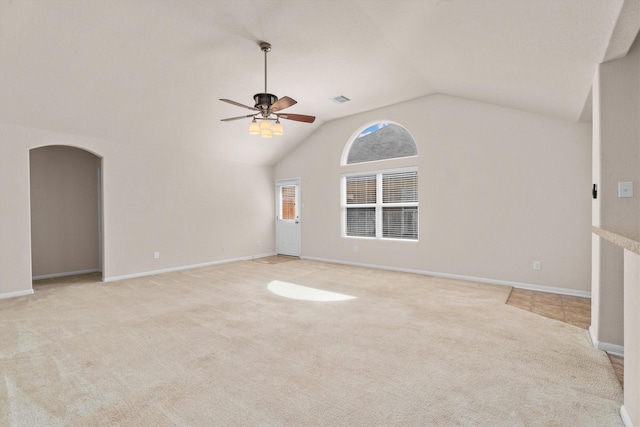 11410 Dahlia Dale Dr, Tomball, TX 77375 - unfurnished living room featuring light carpet, arched walkways, a ceiling fan, vaulted ceiling, and baseboards