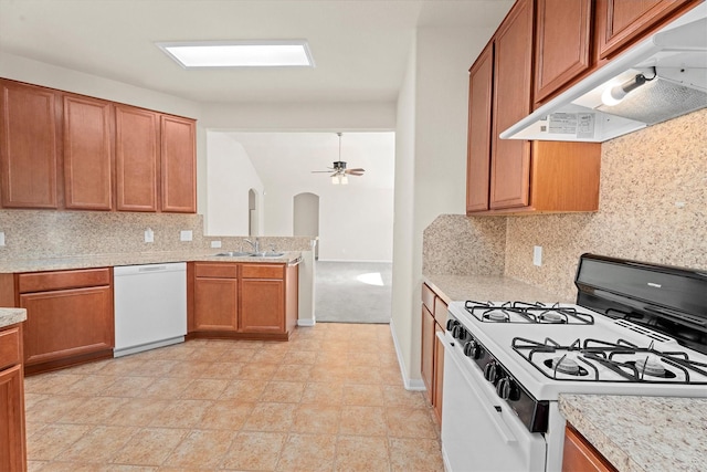 11410 Dahlia Dale Dr, Tomball, TX 77375 - kitchen featuring white appliances, under cabinet range hood, brown cabinetry, tasteful backsplash, and a ceiling fan