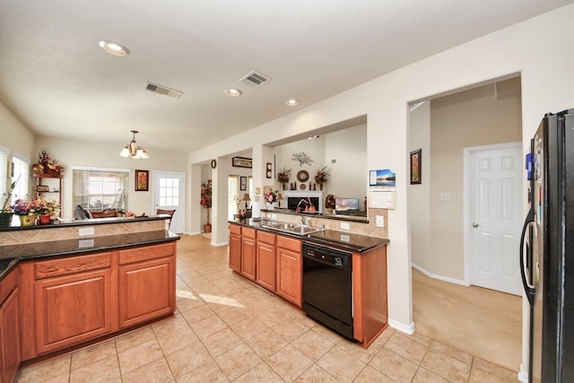 6723 Stableton Ln, Houston, TX 77049 - kitchen with black appliances, a chandelier, brown cabinetry, light tile patterned floors, and recessed lighting