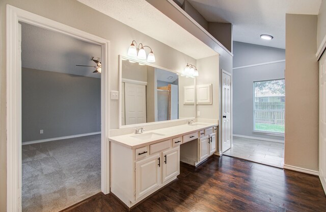 13215 Bunker Hill Dr, Willis, TX 77318 - bathroom featuring vaulted ceiling, ceiling fan, double vanity, baseboards, and a shower with door