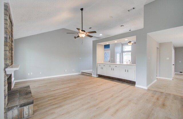 13215 Bunker Hill Dr, Willis, TX 77318 - unfurnished living room with a ceiling fan, light wood-style flooring, baseboards, lofted ceiling, and recessed lighting