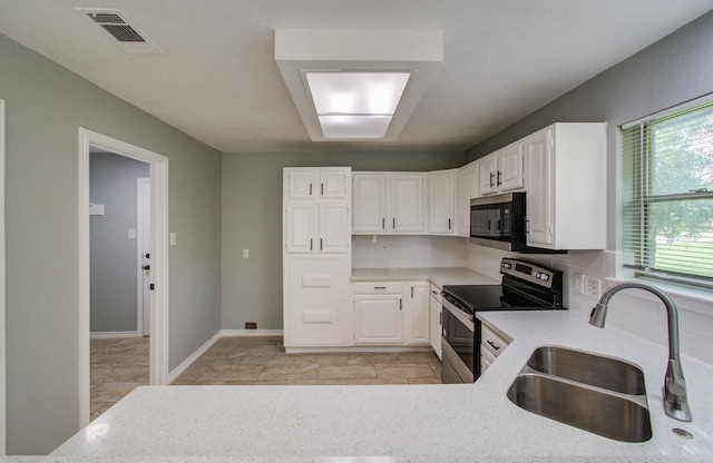 13215 Bunker Hill Dr, Willis, TX 77318 - kitchen with appliances with stainless steel finishes, a sink, white cabinets, backsplash, and light stone countertops