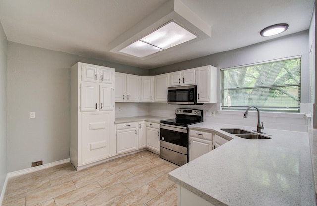 13215 Bunker Hill Dr, Willis, TX 77318 - kitchen featuring stainless steel appliances, a sink, decorative backsplash, white cabinetry, and light stone countertops