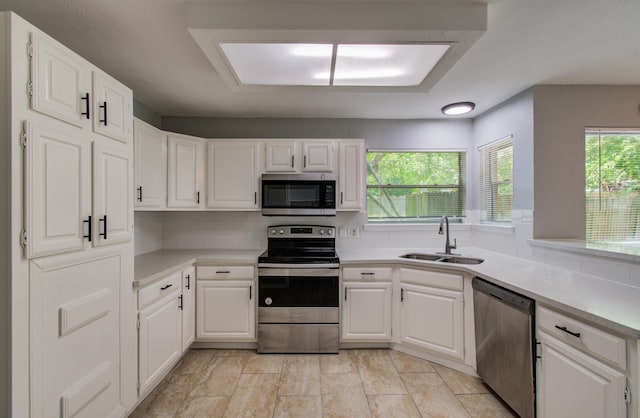13215 Bunker Hill Dr, Willis, TX 77318 - kitchen featuring appliances with stainless steel finishes, a sink, and white cabinetry