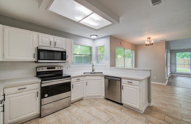 13215 Bunker Hill Dr, Willis, TX 77318 - kitchen with appliances with stainless steel finishes, a sink, a peninsula, and light countertops