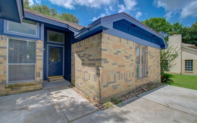 13215 Bunker Hill Dr, Willis, TX 77318 - view of exterior entry with brick siding and a patio